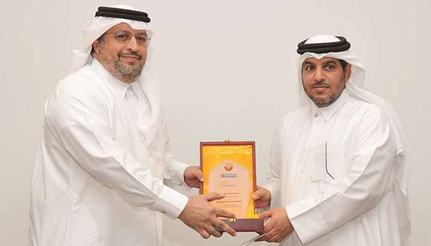 Faisal Abdulhameed al-Mudahka (left) receiving the memento from Ali Abdullah al-Khater.