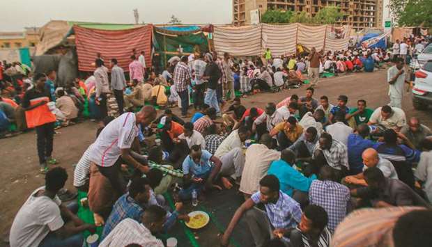 Sudanese protesters gather to break their fast outside the army headquarters in Khartoum yesterday, during the holy month of Ramadan.
