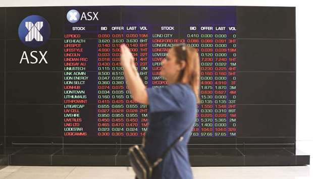 A woman takes a photograph as an electronic board displays stock information at the Australian Securities Exchange in Sydney (file).