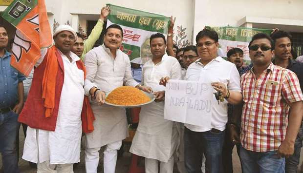 Supporters of the BJP-led National Democratic Alliance distribute sweets as they celebrate after most exit polls showed the NDA getting a comfortable majority in the Lok Sabha elections, in Patna yesterday.