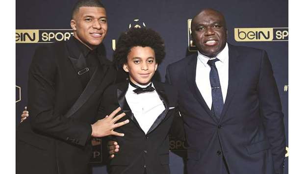 Paris Saint-Germainu2019s French forward Kylian Mbappe (left) poses with his father Wilfried Mbappe (right) and his brother Ethan before he received the Best Ligue 1 Player award at the 28th edition of the UNFP (French National Professional Football players Union) trophy ceremony in Paris on Sunday. (AFP)