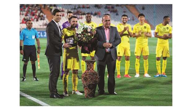 Al Saddu2019s Spanish midfielder Xavi receives gifts from Persepolis officials during the AFC Champions League group D match at the Azadi Stadium in Tehran yesterday. It was the final match of the Spain and Barcelona legendu2019s playing career.