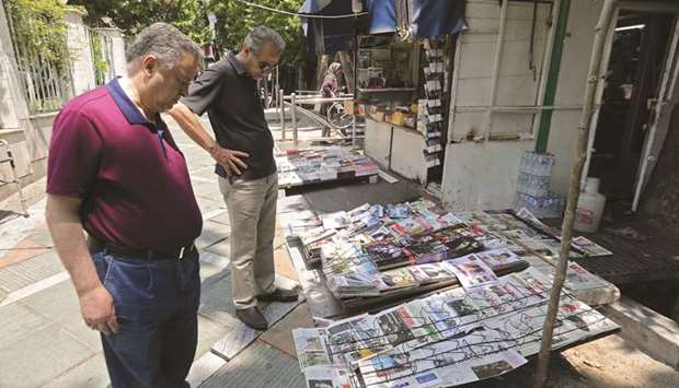 Men read headlines in front of a newspaper stand in the Iranian capital Tehran yesterday.  US President Donald Trump issued an ominous warning to Iran yesterday, suggesting that if the Islamic republic attacks American interests, it will be destroyed.
