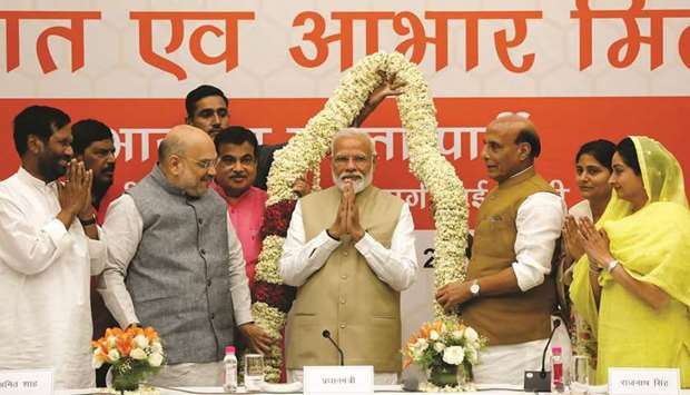 Prime Minister Narendra Modi is presented with a garland during a thanksgiving ceremony by Bharatiya Janata Party (BJP) leaders to allies at the party headquarters in New Delhi yesterday.