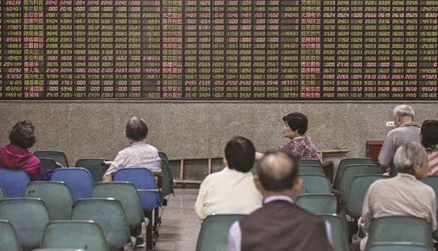 Investors sit in front of an electronic stock board at a securities brokerage in Shanghai. The Shanghai Composite Index rose 1.2% to 2,905.97 points yesterday.
