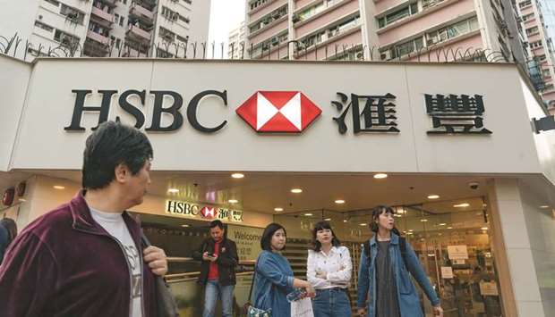 Pedestrians stand outside an HSBC Holdings bank branch in Hong Kong. The bank plans to add more than 1,000 jobs this year at its technology development centres in China, as the Asia-focused lender seeks to bolster its presence in the worldu2019s second largest economy.