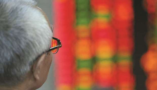An investor watches stocks at a securities exchange in Shanghai (file). For overseas investors, a weaker currency is the latest factor making yuan-denominated assets less attractive.