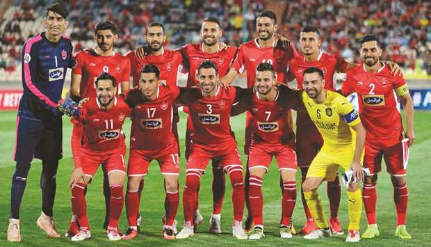 Saddu2019s Spanish midfielder Xavi poses for a picture with Persepolisu2019 starting eleven prior to their AFC Champions League Group D at the Azadi Stadium in Tehran Monday.  At bottom, his Al Sadd teammates cheer as he is presented with a jersey bearing his name by the Persepolis management.