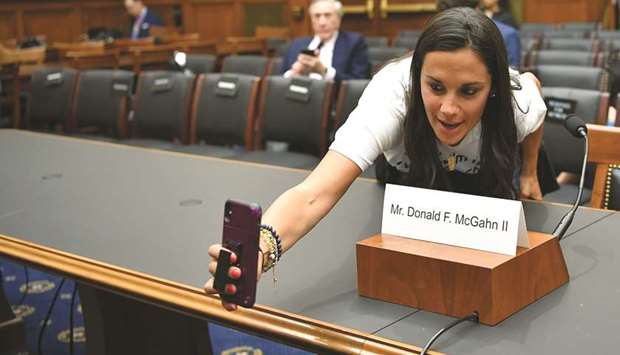 Aletha Shapiro of New York takes a selfie with the name card of Don McGhan at a House Judiciary Committee hearing on the Mueller report on Capitol Hill in Washington yesterday.