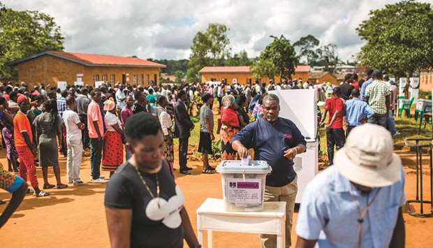A man casts his vote as people wait in line at CCAP Primary School polling station in Mzuzu, Malawi.