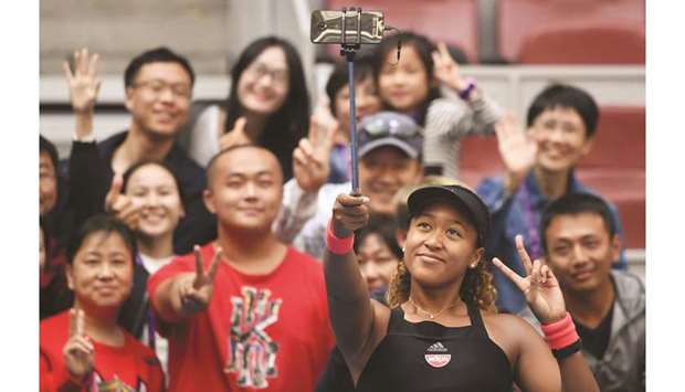 Naomi Osaka of Japan poses with fans after winning her womenu2019s singles third round match against Julia Goerges of Germany at the China Open in Beijing on October 4, 2018. (AFP)