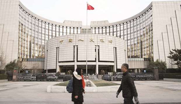 Pedestrians walk past the Peopleu2019s Bank of China headquarters in Beijing. The PBoC set its currency fixing at a level stronger-than-expected for a third straight day. The higher reference rate, which restricts the moves of the onshore yuan by 2% on either side, helped to halt a record slide in the currencyu2019s value against a basket of peers.