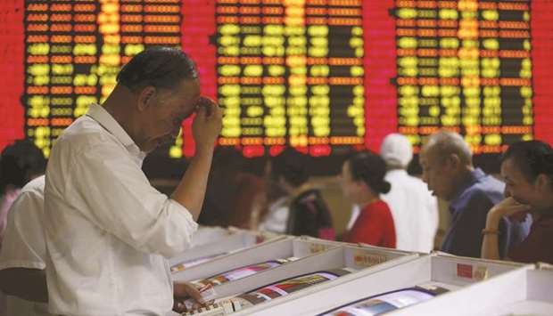 Investors look at computer screens showing stock information at a brokerage house in Shanghai. The Composite index closed down 0.5% to 2,891.70 points yesterday.