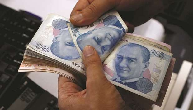 A money changer counts Turkish lira banknotes at a currency exchange office in Istanbul. The lira has fallen nearly 13% so far this year partly over concerns about relations with the US.