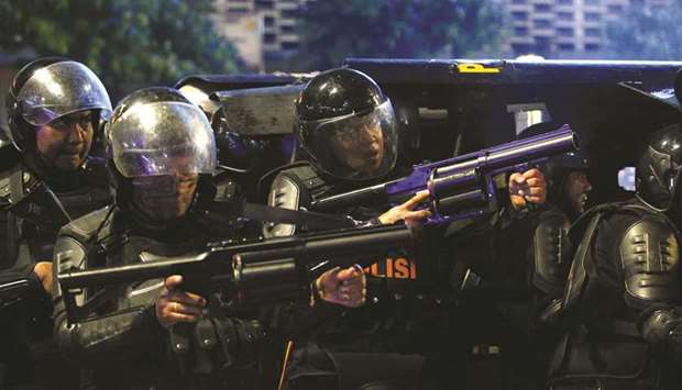 Riot police officers aim tear gas on protesters near the Election Supervisory Agency (Bawaslu) headquarters in Jakarta.