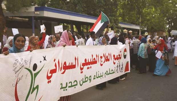 Sudanese medics carry a banner as they hold a rally in front of a hospital in the capital Khartoum.