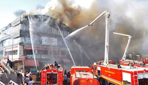 Indian firefighters try to control a major fire in a building housing a college, in Surat
