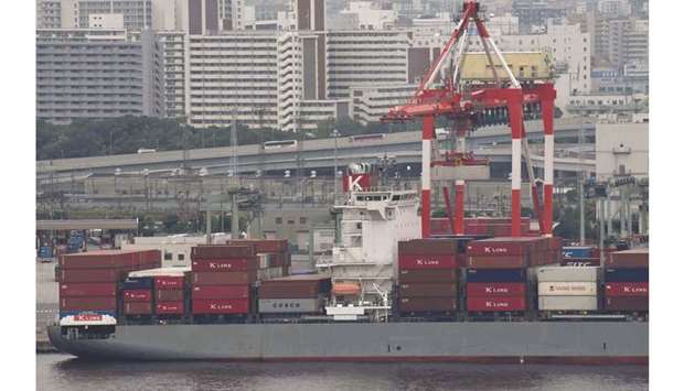 A freighter is anchored at the international container pier at Tokyo port. Japanu2019s government downgraded its assessment of the economy yesterday but maintained the view it was recovering, suggesting that escalating US-China trade tensions have yet to hit growth enough to put off this yearu2019s scheduled sales tax hike.