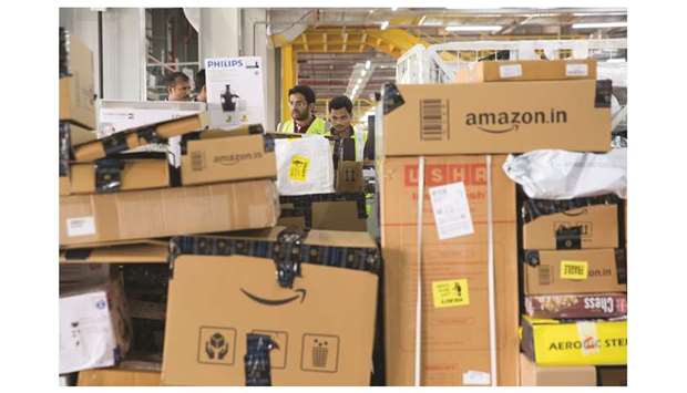 Workers stand behind boxes waiting to be loaded onto outbound trucks at the Amazon Inc fulfilment centre in Bengaluru. Indian Prime Minister Narendra Modiu2019s pro-business image and Indiau2019s youthful population have lured foreign investors, with US firms such as Amazon.com, Walmart and Mastercard committing billions of dollars in investments and ramping up hiring.