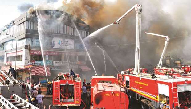 Firefighters try to control the blaze at Takshashila building in Surat yesterday.