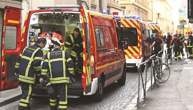Emergency workers attend to an injured person in the back of an ambulance after a suspected package bomb blast along a pedestrian street in the heart of Lyon, southeast France.