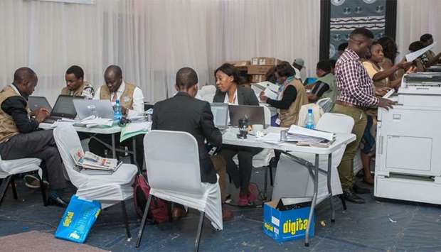 The Malawi Electoral Commission (MEC) staff members work to tabulate and tally votes heavily guarded by military personnel at the National Tally Center following the country's May 21 tripartite elections, in Blantyre