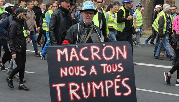 A protester holds a sign reading ,Macron fooled us, (A play on word on US President's name) during a rally called by the ,Gilets Jaunes, (Yellow Vests) movement in Amiens