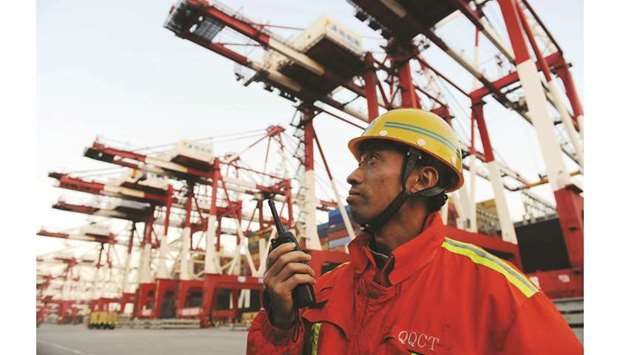 A port worker monitors the unloading of containers on to trucks at the port of Qingdao in northeast Chinau2019s Shandong province (file). Developments in US-China trade negotiations have suddenly changed for the worse as the US hiked tariffs on $200bn of imported Chinese goods from 10% to 25%, QNB has said in a report.