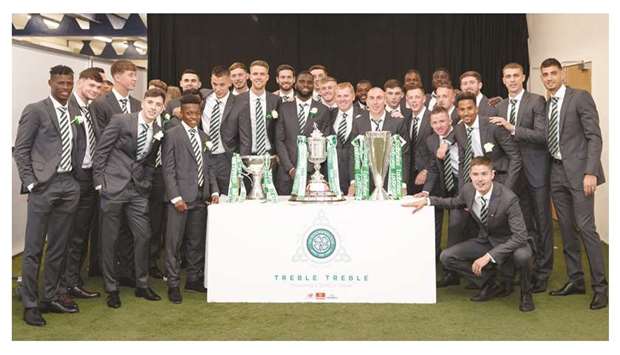 Celtic manager Neil Lennon and players celebrate after winning the treble as they pose with the Scottish League trophy, Scottish Cup and the Scottish Premiership trophy at Hampden Park in Glasgow yesterday. (Reuters)