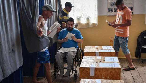 People vote during the European elections and a referendum at a polling station in Comana