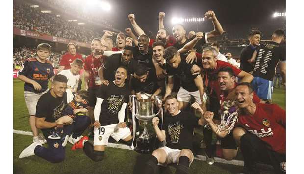 Valenciau2019s players celebrate with the trophy after winning the Spanish Copa del Rey (Kingu2019s Cup) final against Barcelona in Sevilla on Saturday night. (AFP)