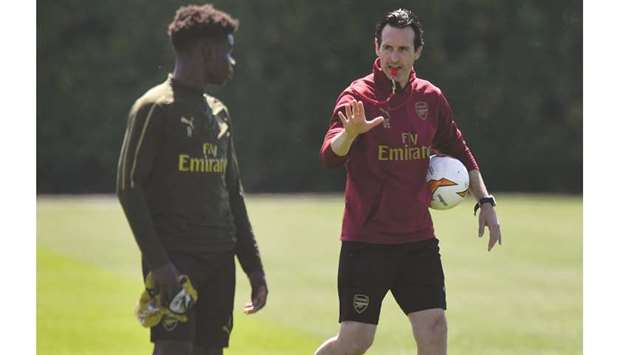 Arsenalu2019s head coach Unai Emery (right) talks to a player during a training session at London Colney training centre in St. Albans. (AFP)