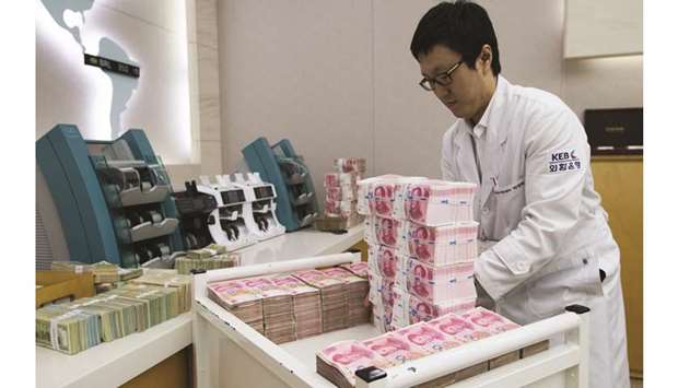 An employee arranges yuan banknotes at the Korea Exchange Bank headquarters in Seoul. The yuan rose to a 1-1/2-week high against the US dollar yesterday, buoyed by a softer greenback and a senior officialu2019s warning not to bet against the Chinese currency.