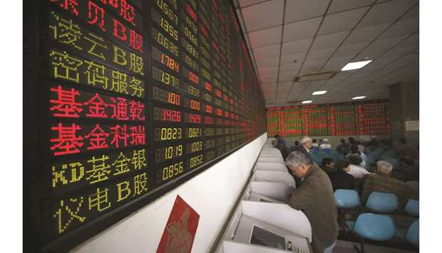 Investors look at computer screens showing stock information at a brokerage house in Shanghai. The Composite index closed up 1.4% to 2,892.38 points yesterday.