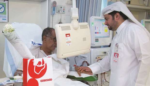 An Ooredoo volunteer talks to a patient at Fahad Bin Jassim Kidney Centre.