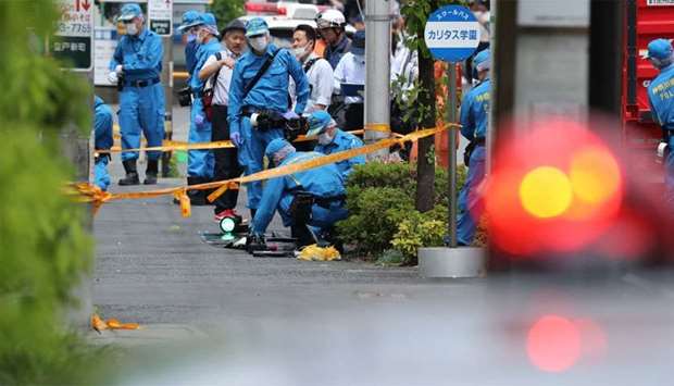 Police forensic experts investigate a crime scene where a man stabbed 19 people, including children in Kawasaki