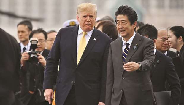US President Donald Trump (left) walks with Japanu2019s Prime Minister Shinzo Abe as he leaves Japanu2019s navy ship Kaga in Yokosuka yesterday. The US wants Japan to cut tariffs on US farm products to restore their competitiveness after Trump shunned an 11-nation Pacific trade pact. Japan has signalled it might cut the levies to levels in the Trans-Pacific Trade Partnership pact.