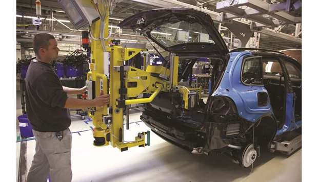 An employee installs a hybrid battery into a VW Touareg sport-utility vehicle at the Volkswagen factory in Bratislava, Slovakia. VW is spending u20ac30bn on the industryu2019s biggest push into electric vehicles with a new range of purely battery-powered cars to challenge electric-car leader Tesla Inc.