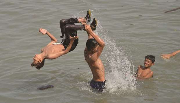 Youths swim in the sea during a hot day in Karachi.