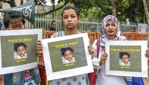 Bangladeshi women hold placards and photographs of schoolgirl Nusrat Jahan Rafi at a protest in Dhaka, following her murder
