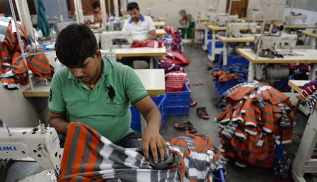 Indian men work at a garment factory in Ludhiana. India's economy grew at a much-lower-than-expected 5.8% in the January-March period, its slowest pace in 17 quarters, and falling behind China's pace for the first time in nearly two years, data showed on Friday.