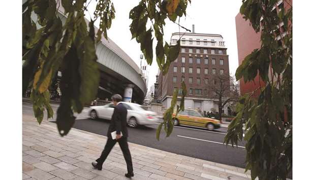 A pedestrian walks near the Nomura Holdings headquarters in Tokyo. Japanu2019s biggest brokerage has suffered another setback after losing a key role in a $12bn share sale following its censure for mishandling stock-market information.