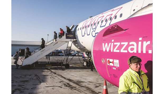 Passengers disembark from an Airbus A321-231 aircraft operated by Wizz Air Holdings, as ground crew carry out checks, at Liszt Ferenc airport in Budapest, Hungary. Wizz Air says profit would rise in the coming year and it expects opportunities to lift market share as competitors withdraw unprofitable capacity in the face of more costly fuel.
