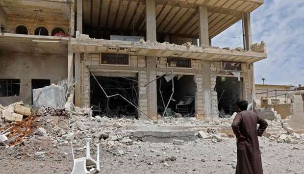 A man stares at a building damaged during reported shelling by government and allied forces, in the town of Hbeit in the southern countryside of the rebel-held Idlib province