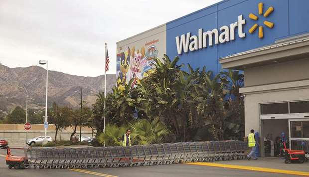 Employees push shopping carts outside a Walmart store in Burbank, California. Walmart plans to bankroll at least a half dozen original programmes over the next year, and will unveil the first few to advertisers in New York this week, sources say.