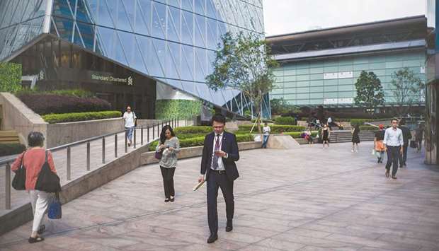 People walk outside the Hong Kong Stock Exchange building. The Hang Seng closed up 0.5% to 30,081.55 points yesterday.