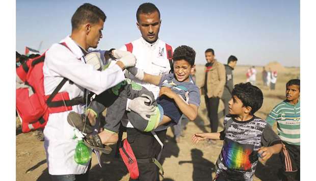 A wounded Palestinian boy is evacuated during a protest at the border fence, in the southern Gaza Strip, yesterday.