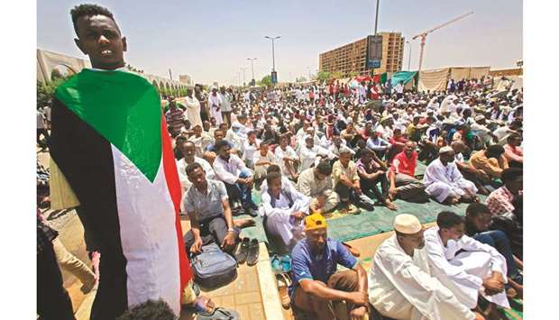Sudanese protesters gather during noon prayers outside the army headquarters in Khartoum, yesterday, as they continue protests demanding that the ruling military council hand power to a civilian administration.