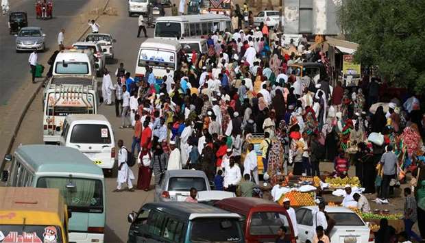 Sudanese residents wait for buses on a street in Khartoum, Sudan