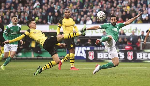 Borussia Dortmundu2019s Julian Weigl (left) and Werder Bremenu2019s Claudio Pizarro go acrobatic for the ball during the Bundesliga match yesterday. (Reuters)